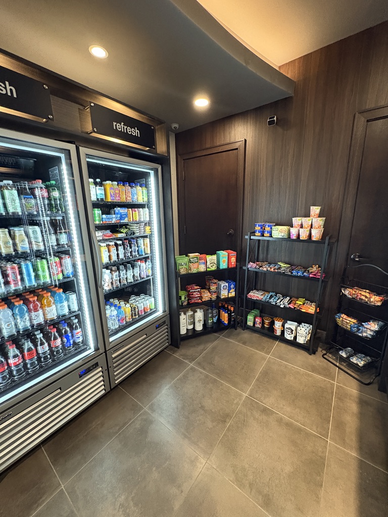 Micro Market interior view showing beverage coolers, organized shelving with snacks and products